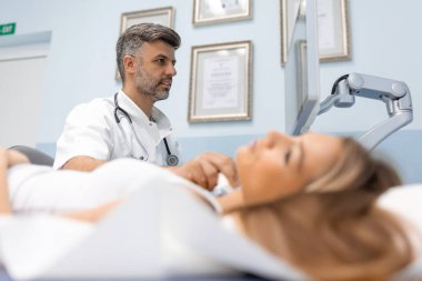 Modern klinikte genç bir kadının ultrason tarayıcısı kullanarak boynunu muayene ettirdiği yakın plan bir fotoğraf..