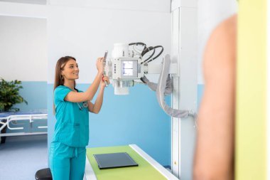 Hastanede, X-Ray Makinesi onu tararken, duvarın karşısında duran adam. Kırıklar, kırık uzuvlar, göğüs ve kanser taraması. Teknolojik Gelişmiş Tıbbi Ekipmanlı Modern Hastane.