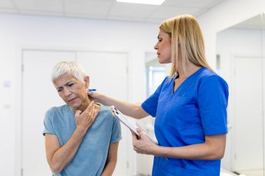 Lisanslı kayropraktik uzmanı ya da klinikteki kadın hastaya boyun masajı yapan manuel terapist. Omurga incinmesi ya da romatolojik sorunu olan genç bir kadın profesyonel doktordan yardım alıyor.