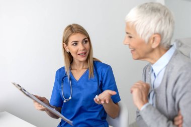 Genç bayan profesyonel doktor hastaya danışmanlık yapıyor, sağlık kontrolünde üst düzey kadın müşteriyle konuşuyor. Hastalık tedavisi. Tıbbi sağlık konsepti