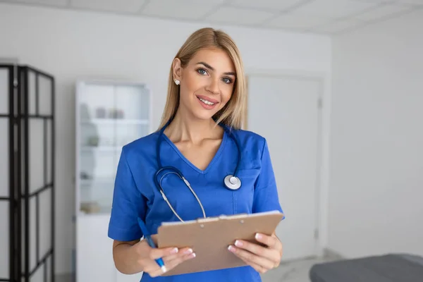 Portrait of female health care professional, doctor, with stethoscope. Portrait of beautiful mature woman doctor holding digital tablet and looking at camera.