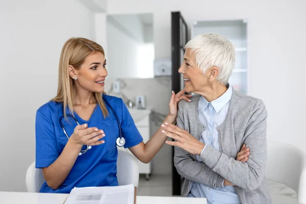 Portrait of female doctor explaining diagnosis to her patient. Female Doctor Meeting With Patient In Exam Room. Shot of a medical practitioner reassuring a patient