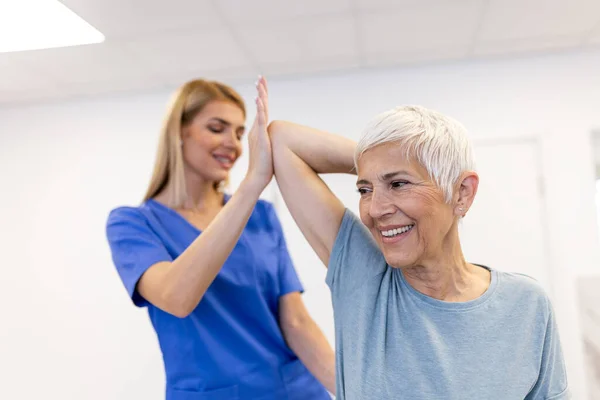 Orvos Vagy Fizioterapeuta Dolgozik Vizsgálata Sérült Kar Idősebb Női Beteg Stock Kép
