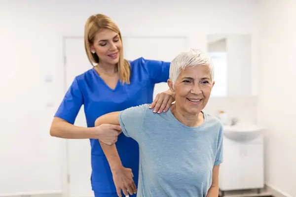 Doctor Physiotherapist Working Examining Treating Injured Arm Senior Patient Stretching Stock Image