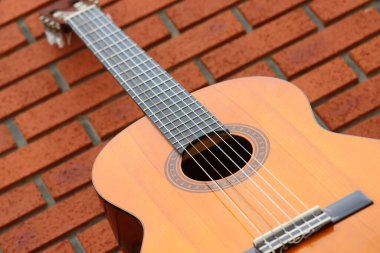 Tuğla duvarın önünde akustik gitar