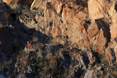 Katmanlı kayalar ve tepeler. Doğal taştan kahverengi bir yüzey.