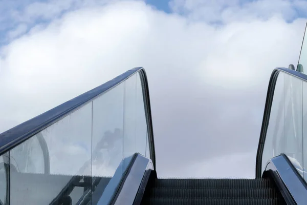 白い雲と日当たりの良い青空に向かって上昇するオープンエアのエスカレーター — ストック写真