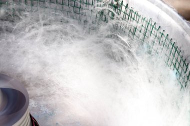 Pamuk şeker yapıyorum. Sokak yemekleri ve karnaval lezzeti kavramı..