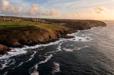 Güneş batarken Cornwall 'daki Pendeen Deniz Feneri' nin güzel hava aracı görüntüsü güzel renkler ve gökyüzü