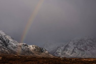 İskoçya Highlands Rannoch Stob Dearg 'daki dağların önündeki göz alıcı gökkuşağı manzarası.