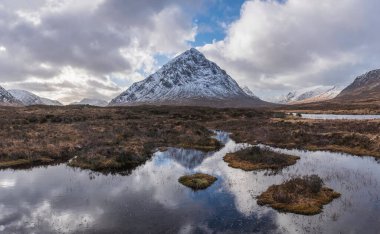 Önplanda Etive Nehri 'nin güzel kış manzarası. Arkaplanda ikonik kar örtülü Stob Dearg Buachaille Etive Mor dağı var.