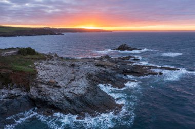 Güneş doğarken Cornwall İngiltere 'de atmosferik karamsar gökyüzü ve bulutlarla Prusya Koyu' nun çarpıcı hava aracı görüntüsü