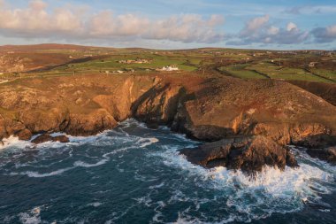 Güneş batarken Cornwall 'daki Pendeen Deniz Feneri' nin güzel hava aracı görüntüsü güzel renkler ve gökyüzü