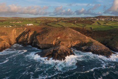 Güneş batarken Cornwall 'daki Pendeen Deniz Feneri' nin güzel hava aracı görüntüsü güzel renkler ve gökyüzü