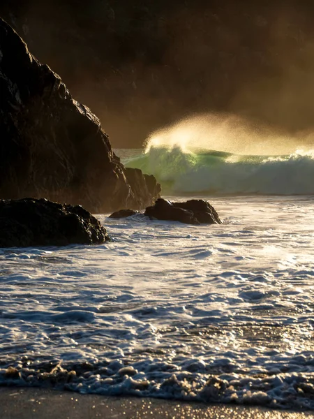 바위에 쏟아지는 풍경을 배경으로 과바람에 물방울을 뿌린다 — 스톡 사진