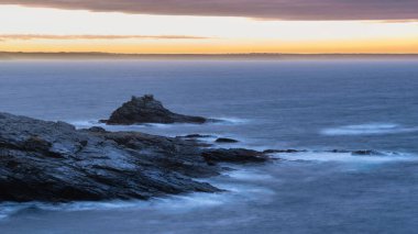 Atmosferik gökyüzü ve okyanusla Cornwall İngiltere 'deki Prusya Koyu' nda karamsar manzara gündoğumu görüntüsü