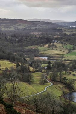 Beautiful Winter sunrise golden hour landscape view from Loughrigg Fell across the countryside in the Lake District