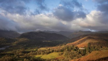 Beautiful Winter sunrise golden hour landscape view from Loughrigg Fell across the countryside towards Langdale Pikes in the Lake District