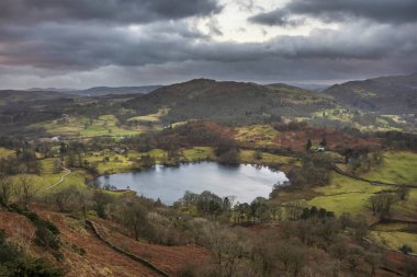 Beautiful Winter sunrise golden hour landscape view from Loughrigg Fell across the countryside in the Lake District