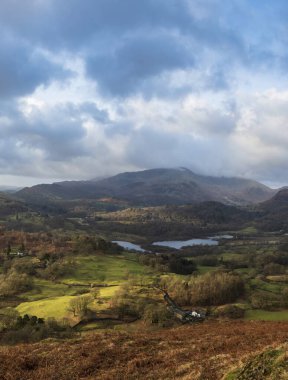 Beautiful Winter sunrise golden hour landscape view from Loughrigg Fell across the countryside towards Langdale Pikes in the Lake District