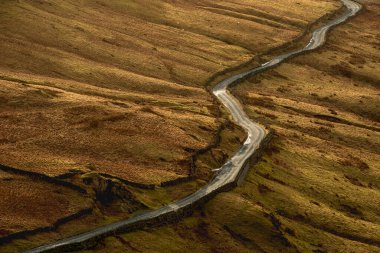 Early morning Winter landscape view of road cutting through Lake District countryside