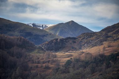 Beautiful Winter landscape views of mountain ranges around Ullswater in Lake District viewed from boat on lake