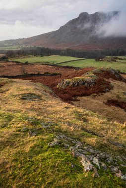 Stunning Winter sunset golden hour landscape image of view from Wast Water over countryside in Lake District towards the Western district