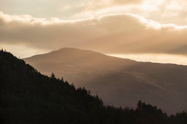 Dramatic Winter landscape image looking across countryside in Lake District with hard frost on the ground and crisp blue sky