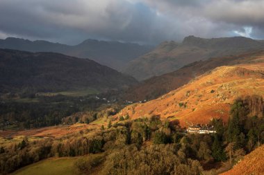 Beautiful Winter sunrise golden hour landscape view from Loughrigg Fell across the countryside towards Langdale Pikes in the Lake District