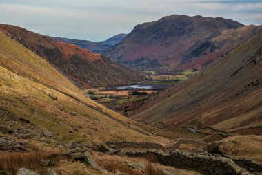 Early morning Winter landscape view of road cutting through Lake District countryside towards Brothers Water through the valley