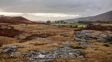 Stunning Winter sunset golden hour landscape image of view from Wast Water over countryside in Lake District towards the Western district