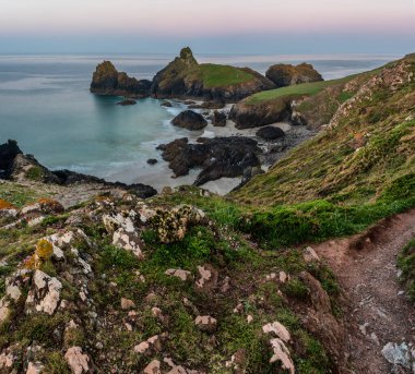 Popüler turistin göz kamaştırıcı gün doğumu ve gün batımı manzarası Cornwall İngiltere 'deki Kynance Koyu' nda renkli gökyüzü