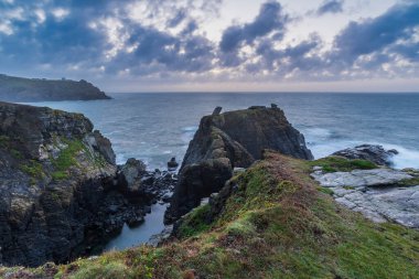 Güzel dramatik yaz gündoğumu Cornwall UK 'de Kertenkele Noktası üzerinde güzel parlayan gökyüzü ve bulutlarla