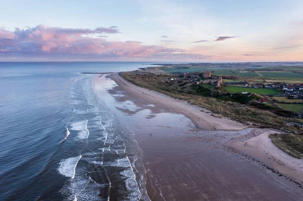 Beautiful aerial drone landscape image of Northumberland beach in Northern England during Winter sunrise