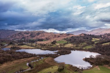 Brathay nehri üzerinde, Elterwater Gölü yakınlarındaki Langdale Pikes 'le güzel bir hava aracı manzarası.