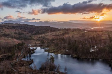 Stunning aerial drone landscape image of Lake District during Spring vibrant sunset clipart