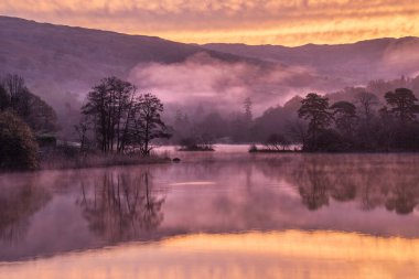 Muhteşem sonbahar gündoğumu. Rydal Su 'nun inanılmaz renklerle dramatik manzarası.