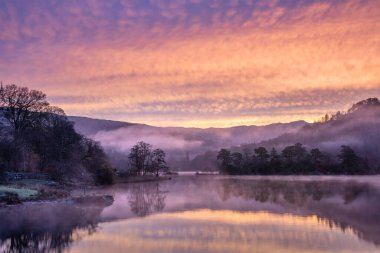 Stunning beautiful Autumn sunrise dramatic landscape image of Rydal Water in Lake District with unbelievable colours clipart