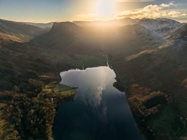 Stunning aerial drone landscape in Autumn Winter of snowcapped mountains around Buttermere in Lake District at sunrise clipart