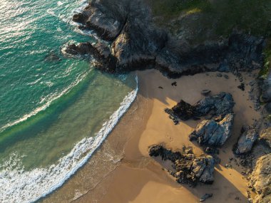 Cornwall 'daki Holywell Körfezi' nin canlı yaz günbatımında çekilmiş güzel hava aracı manzarası. 