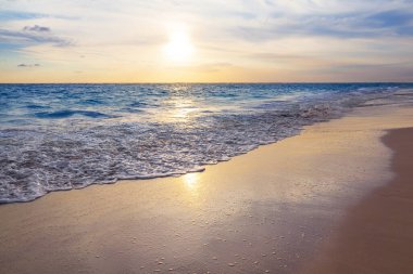 Punta Cana, Dominik Cumhuriyeti 'nde Atlantik Okyanusu üzerinde güzel bir gündoğumu. Ufukta ve denizde altın renklerde canlı bir gün doğumu.