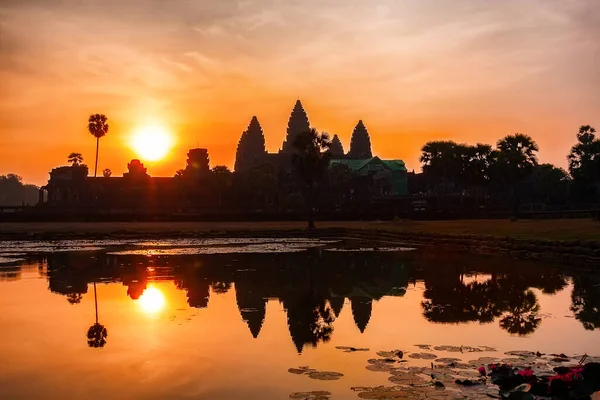Angor Wat temple at sunrise in Siem Reap, Cambodia. Ancient Angkor Wat temple in Siem Reap, Cambodia silhouette at sunrise with reflection.
