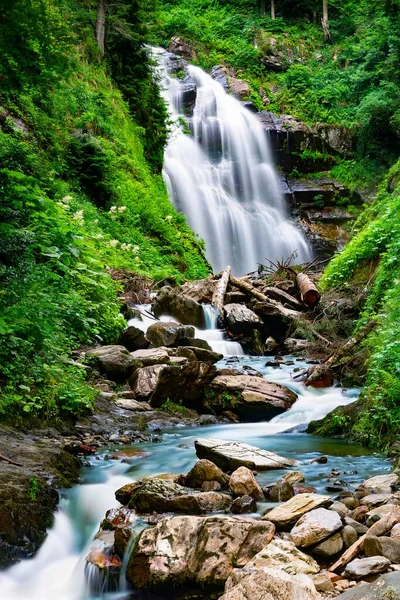Waterfall cascade on mountain rocks. A mountain waterfall flows over the rocks. Deep rainforest waterfall view.