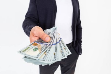 Genç ve şık bir adam bir dolar nakit para veriyor. 2000 dolar. 100 'lük banknotlar halinde. Beyaz arka planda, yakın plan.. 