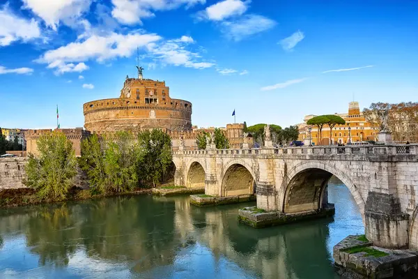 Roma, İtalya 'da güneşli bir günde Castel Sant' Angelo ve Tiber nehri üzerindeki Sant 'Angelo köprüsü. Roma, İtalya 'da Kutsal Melek Kalesi (Castel Sant' Angelo) ve Aziz Angel Köprüsü (Ponte Sant 'Angelo).