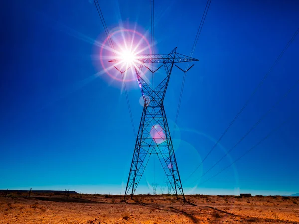 太陽に照らされた高張力の電気タワー ストック画像