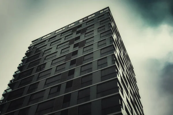 暗い曇りの空の角度ショットとガラスの建物 — ストック写真