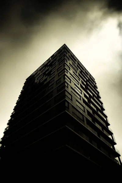 Edifício Vidro Com Escuro Ângulo Céu Nublado Tiro — Fotografia de Stock