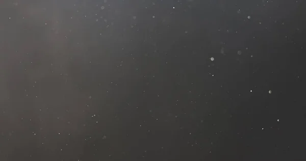 黒い空に浮かぶ本物の塵の粒子のショット — ストック写真