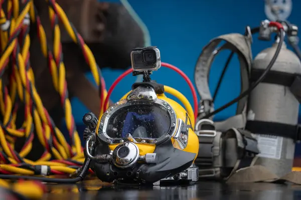 Commercial diving helmet closeup photo with gear in the background